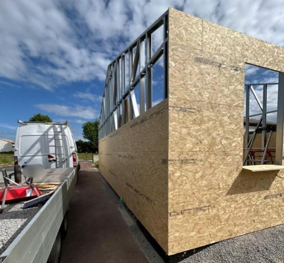 Extension de maison en ossature métallique légère bardée d'OSB, en cours de chantier